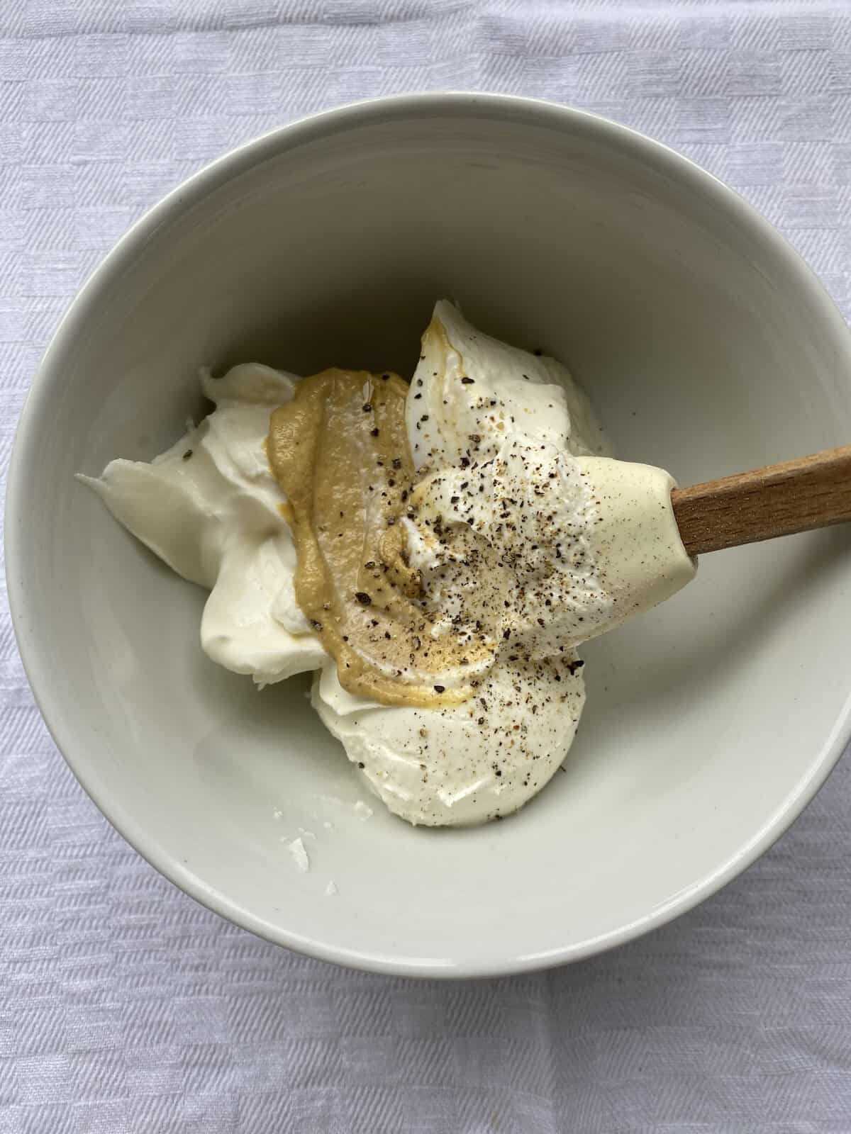 Cream Cheese, mustard and pepper in a white dish.