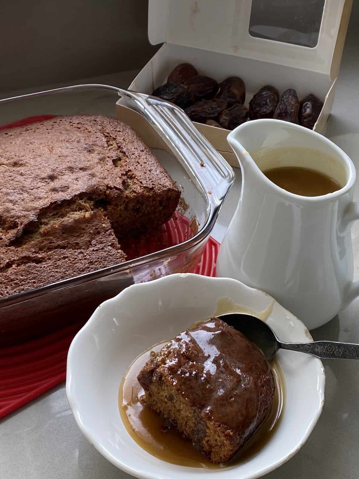 Sticky Toffee Pudding with a portion cut out and sauce poured over it