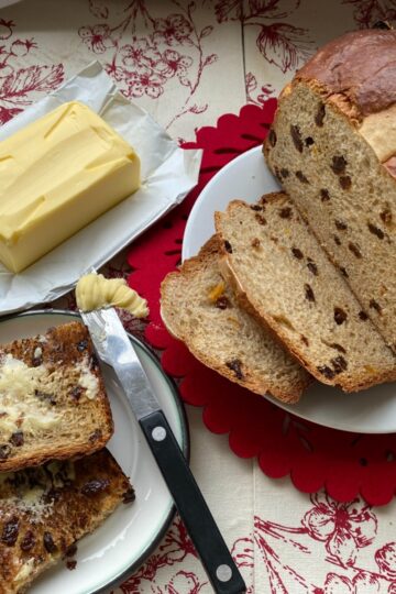 Hot Cross Bun Loaf with buttered slices on a plate.