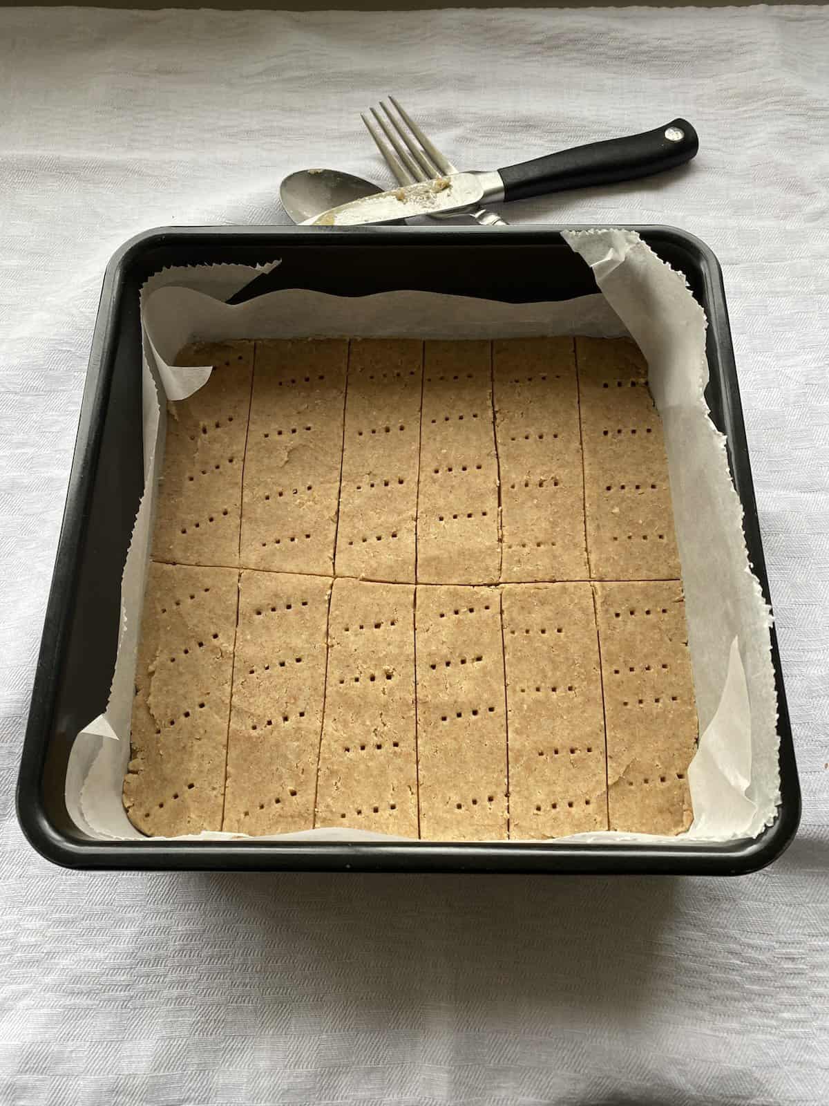 Unbaked shortbread dough in a baking tin.