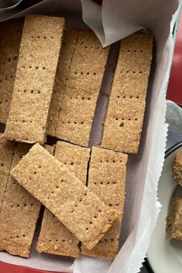 Shortbread biscuits stored in a square tin.